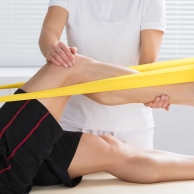 Physiotherapist Giving Treatment With Exercise Band